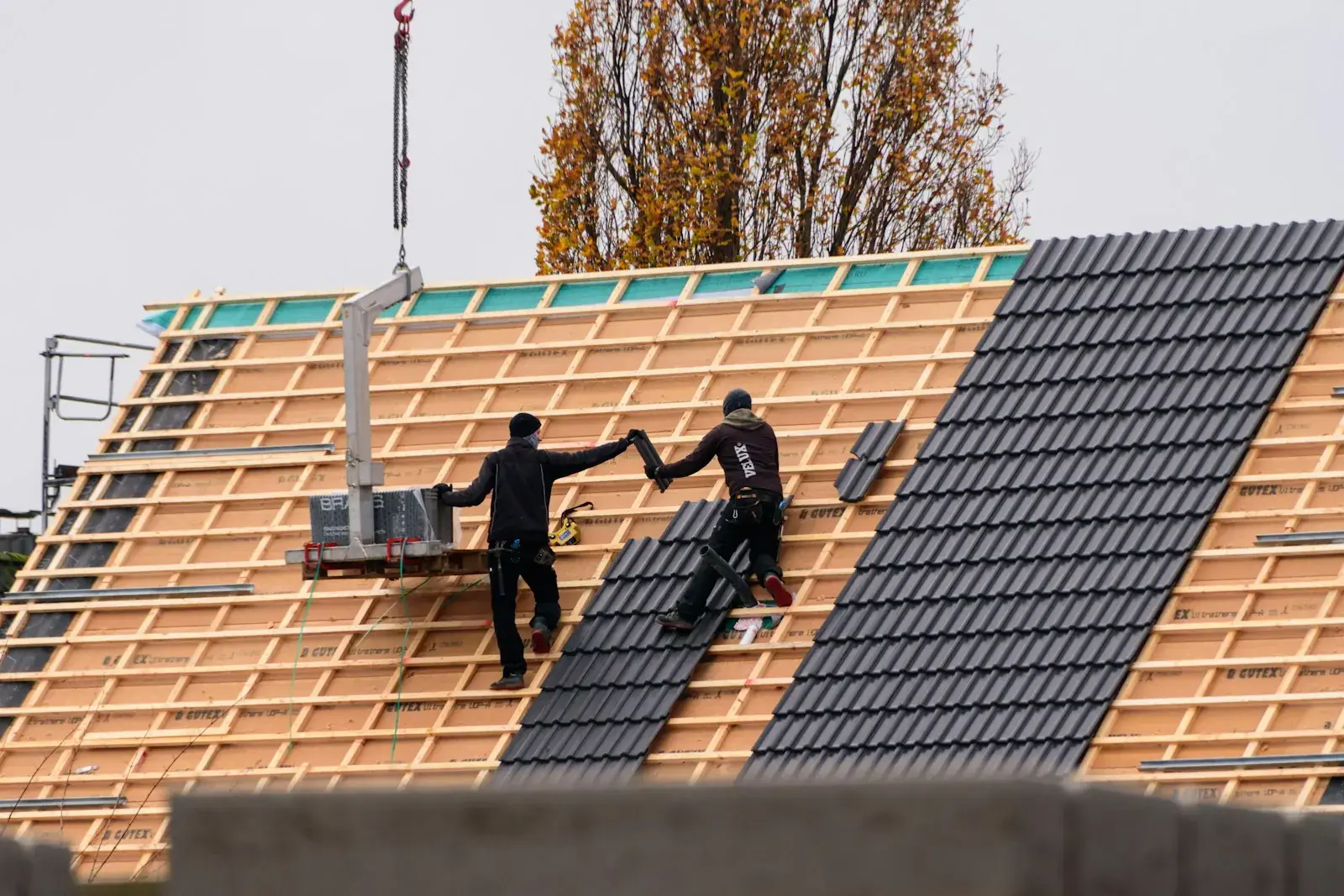 Roofers laying tiles on a new roof